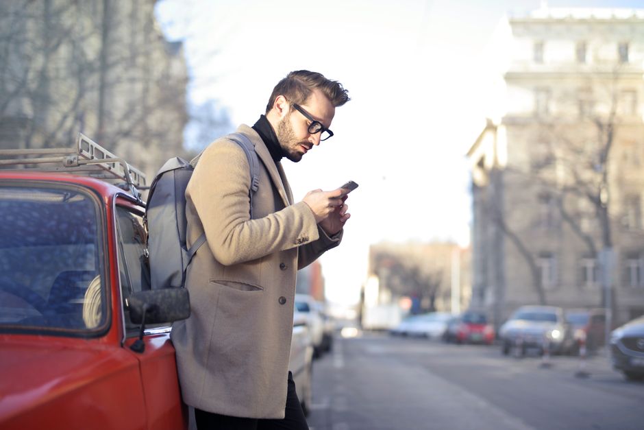 Person on phone next to car - Traffic fines in a hire car in South Africa